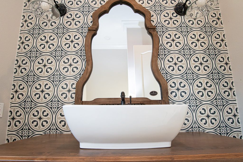A bathroom sink with a mirror and a wooden frame.